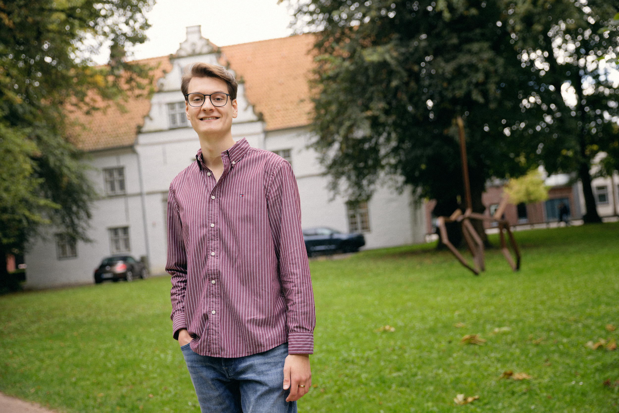 Skade Nielsen Niquet (FDP), Landtagskandidat Nordfriesland-Süd 2027, im karierten Hemd vor dem Schloss vor Husum